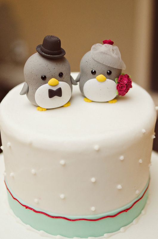 animal cake toppers This penguin is wearing a birdcage veil and carrying a red rose bouquet. Wedding photographer: Weber Photography.