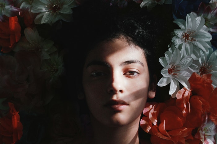 A womans face surrounded by flowers 