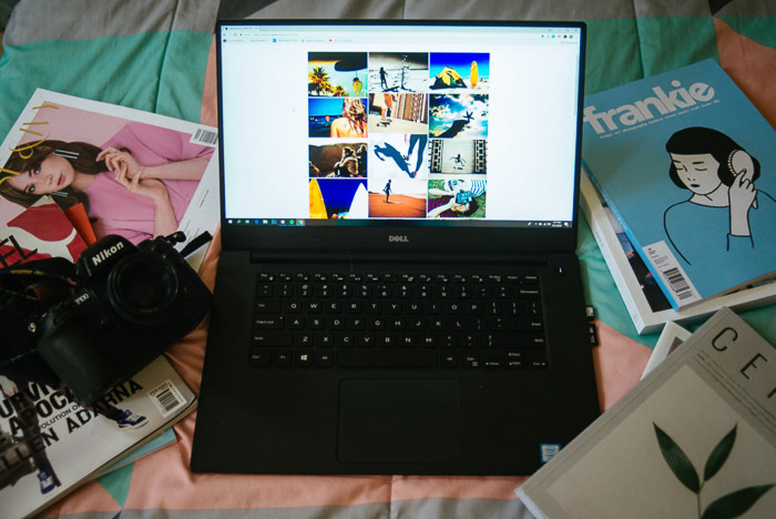 A still life of a laptop on a bed with different magazines scattered around