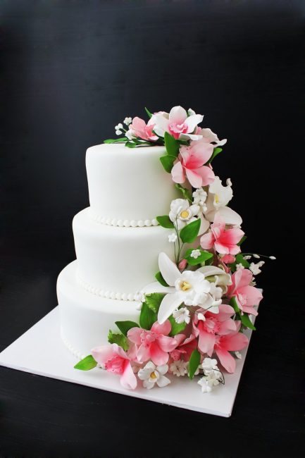 Свадебный торт, украшенный искусственными цветами 