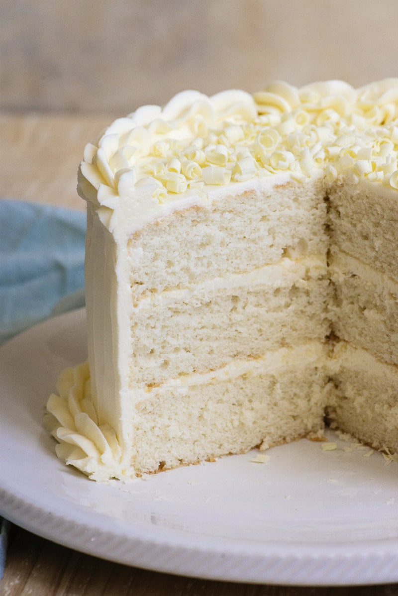 Easy White Wedding Cake recipe from RecipeGirl.com #easy #white #wedding #cake #recipe #RecipeGirl Sliced open three layer White Wedding Cake on a white platter